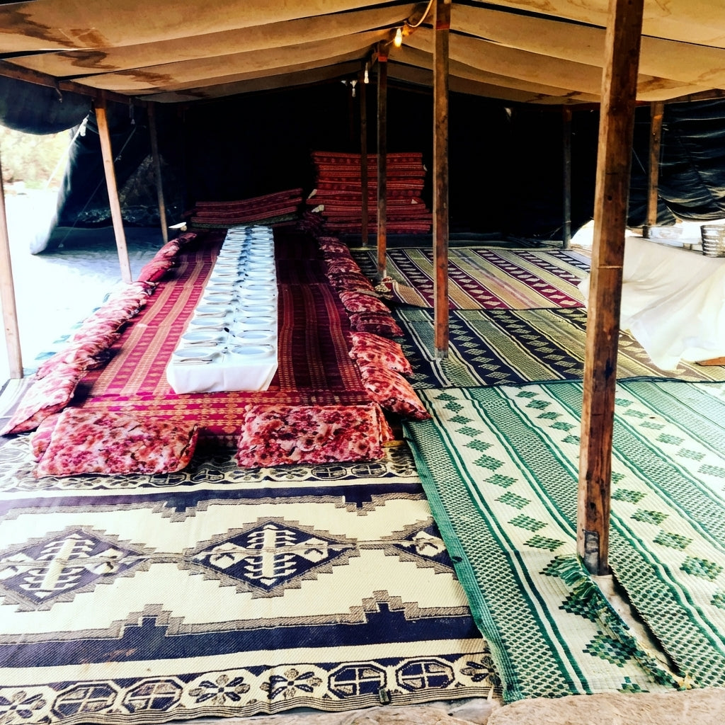 A low, layered gathering space with soft textiles — the Bedouin zula that inspired the Zoola name